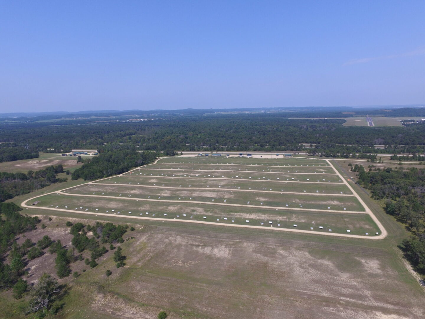Aerial view of a large outdoor storage area with numerous aligned units under a clear blue sky.