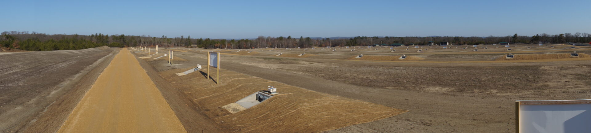 A panoramic view of a construction site with various stages of infrastructure development on a clear day.