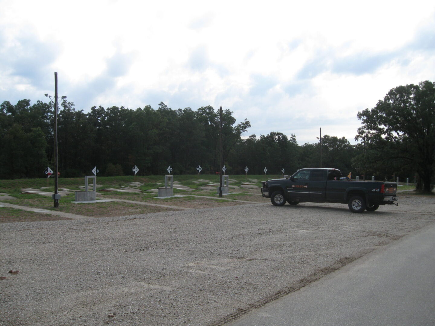 Pickup truck parked by a roadside near a series of memorial crosses.